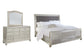 Coralayne King Upholstered Sleigh Bed with Mirrored Dresser